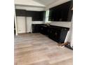 Modern kitchen featuring sleek black cabinets, countertops, and new wood flooring at 2352 Ross St, Kissimmee, FL 34744