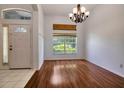 Bright entryway featuring hardwood floors, a large window, and a traditional chandelier at 2674 Sugar Pine Run, Oviedo, FL 32765