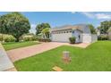 Home exterior with brick driveway, verdant lawn, and partial white fence at 2674 Sugar Pine Run, Oviedo, FL 32765