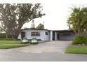 Charming single-story home with mature tree, carport, well-manicured lawn and lush landscaping at 319 Halsey St, Orlando, FL 32839
