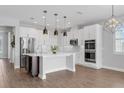 Modern kitchen with white cabinets, stainless steel appliances, a center island, and stylish pendant lighting at 32004 Redtail Reserve Blvd, Sorrento, FL 32776