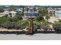 Exterior view of a luxurious multi-story home with stairs leading to the beach at 3309 Hill St, New Smyrna Beach, FL 32169