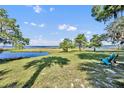 Picturesque backyard featuring lush green grass with trees, a pond, and relaxing outdoor seating, kayak, and canoe at 419 Whitcomb Dr, Geneva, FL 32732