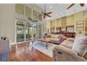 Elegant living room boasting hardwood floors, soaring ceilings, and large windows with scenic views at 419 Whitcomb Dr, Geneva, FL 32732
