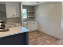 Bright kitchen with an island, white cabinets, open shelving, and modern countertops at 4720 Oak St, Fruitland Park, FL 34731