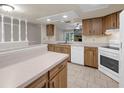 Open kitchen with wood cabinets, tile floors, and white appliances at 525 Garden Heights Dr, Winter Garden, FL 34787