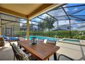 Relaxing screened-in patio area with dining table, lounge chairs, pool, and spa for outdoor enjoyment at 5368 Oakbourne Ave, Davenport, FL 33837