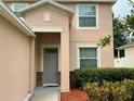 Inviting front entrance with a gray door and lush landscaping at 5917 Coquyt Dr, Mount Dora, FL 32757