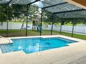 Screened in pool with clear blue water and outdoor playset at 5917 Coquyt Dr, Mount Dora, FL 32757