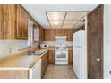 Functional kitchen with wood cabinets, tile flooring, and a double stainless steel sink at 6835 Massa Ct, Orlando, FL 32810