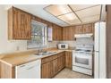 Functional kitchen with wood cabinets, tile flooring, and a double stainless steel sink at 6835 Massa Ct, Orlando, FL 32810