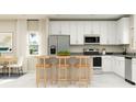 Modern kitchen boasts stainless steel appliances, white cabinets, and a breakfast bar at 7374 Ivy Tendril Ave, Orlando, FL 32829