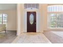 Inviting entryway features a decorative glass door, tile flooring, and large windows for natural light at 1154 Feather Dr, Deltona, FL 32725