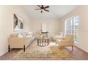 Bright living room with a large arched window, neutral decor, and comfortable seating arrangement at 1154 Feather Dr, Deltona, FL 32725