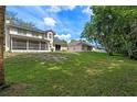 Expansive backyard featuring a screened in porch, a lush lawn, and mature trees at 1225 Hollow Pine Dr, Oviedo, FL 32765