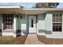 Inviting front entrance showcasing a white door, decorative sidelight, and exterior light fixture at 12419 Eryn Ct, Clermont, FL 34711