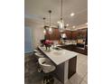Stylish kitchen features a quartz island with pendant lighting and modern appliances at 1259 Pando Loop, Orlando, FL 32824