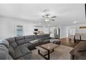 Spacious living room connected to a kitchen and dining area with a large gray sectional at 12835 Del Lago Dr, Astatula, FL 34705