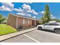 Side view of a red brick duplex with a manicured lawn and convenient parking, radiating curb appeal at 1288 Americana Pl, Orlando, FL 32807