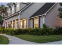 Stylish home featuring a covered front porch with elegant columns, lush landscaping, and a neatly trimmed lawn at 1443 Stone Trl, Enterprise, FL 32725