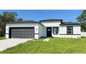 A bright single-Gathering home featuring a gray garage door and minimalist modern design at 16252 Sw 27Th Terrace Rd, Ocala, FL 34473