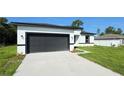 A single-Gathering home showcasing a spacious driveway and a contemporary gray garage door at 16252 Sw 27Th Terrace Rd, Ocala, FL 34473