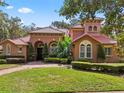 Charming home exterior with arched entryway, manicured landscaping, and a welcoming brick path at 1813 Glenbay Ct, Windermere, FL 34786