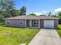 Charming single-story home with a well-manicured lawn, driveway, and attached one car garage, under a sunny sky at 1816 Alexander Ave, Sanford, FL 32771