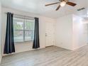 Bright living room with wood look flooring, a ceiling fan, and dark colored curtains at 1816 Alexander Ave, Sanford, FL 32771