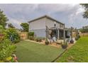 Well-maintained backyard with a grass area, beautiful planters, and seating under string lights at 2032 Wavyleaf Ct, Apopka, FL 32712