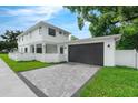 Spacious two-car garage featuring a paved driveway, set against a pristine white fence and lush lawn at 2300 S Brown Ave, Orlando, FL 32806