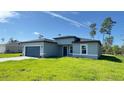 Inviting single-story home featuring manicured lawn, attached garage and covered entrance in a modern style at 2500 Sw 156Th Ln Rd, Ocala, FL 34473