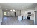 Bright, open-concept kitchen with white cabinets, stainless steel appliances, and an island with seating at 2500 Sw 156Th Ln Rd, Ocala, FL 34473