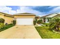 The property offers a spacious two-car garage with a wide driveway and well-maintained lawn at 2932 Whispering Trails Dr, Winter Haven, FL 33884