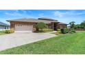 Brick home featuring a well-maintained lawn, attached garage, and carefully trimmed landscaping at 3604 Shell Cove Ln, Orlando, FL 32817