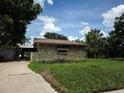 Home exterior featuring a stone wall, garage, and covered area at 4415 Raymar Dr, Orlando, FL 32839