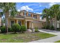 Beautiful two-story home with a lush front lawn, mature palm trees, and a two-car garage, perfect curb appeal at 5172 Oakbourne Ave, Davenport, FL 33837