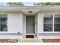 Inviting front entrance featuring a modern gray door, freshly painted trim, and convenient digital lock at 5430 Nw 55Th Pl, Ocala, FL 34482