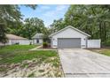 Single-story home with a two car garage, gray accents, a well-maintained lawn and a cozy, inviting entrance at 5430 Nw 55Th Pl, Ocala, FL 34482