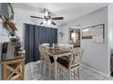 Bright dining area with a ceiling fan, a decorative chandelier, and a rustic table set at 565 S Floyd Cir, Deltona, FL 32725