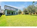 Expansive backyard with lush green grass, mature trees, and a covered patio area at 6925 Trellis Vine Loop, Windermere, FL 34786