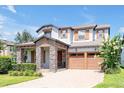 Charming two-story home featuring stone accents, a paved driveway, and a well-manicured lawn at 6925 Trellis Vine Loop, Windermere, FL 34786