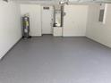 Clean and spacious two-car garage featuring painted walls and epoxy floors at 1027 Sheeler Hills Dr, Apopka, FL 32703