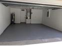 Clean and spacious two-car garage featuring painted walls and epoxy floors at 1027 Sheeler Hills Dr, Apopka, FL 32703