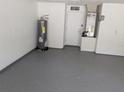 Clean and spacious two-car garage featuring painted walls and epoxy floors at 1027 Sheeler Hills Dr, Apopka, FL 32703