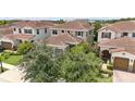 A two-story home with a red tile roof and a manicured lawn with a two-car garage at 10275 Henbury St, Orlando, FL 32832