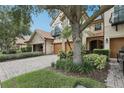 Charming townhome featuring a stone facade, private balcony, and a paver driveway leading to a two-car garage at 10423 Belfry Cir, Orlando, FL 32832