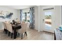 Bright dining area with a modern table, stylish chairs, and elegant blue patterned curtains at 1188 Alstonia Ln, Mount Dora, FL 32757