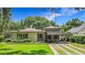 Charming single story home with mature landscaping, porte-cochere, and well-maintained lawn at 1606 Orangewood Ave, Orlando, FL 32806