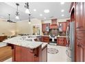 Gourmet kitchen boasts custom cabinets, granite countertops, and stainless steel appliances at 1689 Wingspan Way, Winter Springs, FL 32708